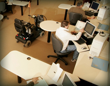 Student with scooter at work on computer.