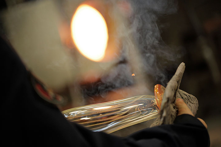 An artist manipulating molten glass