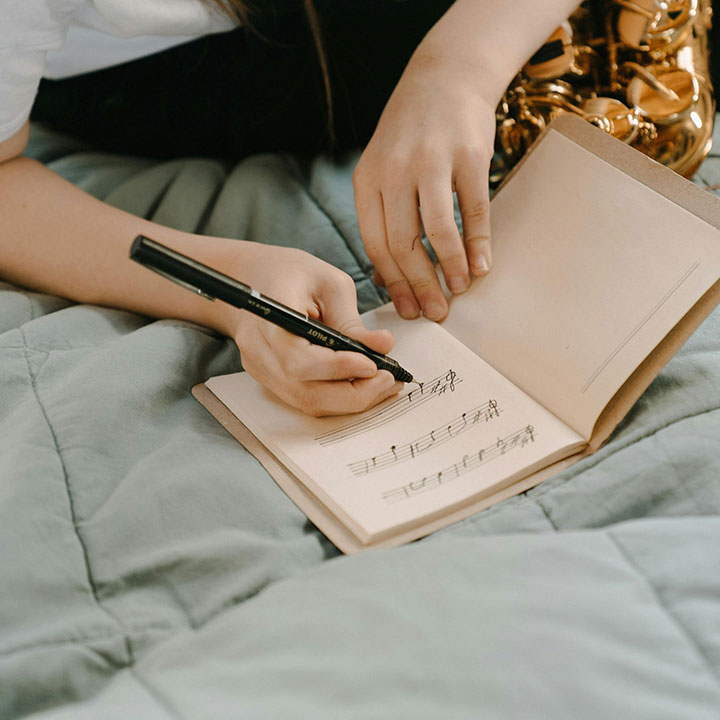 A person writing a song in a notebook