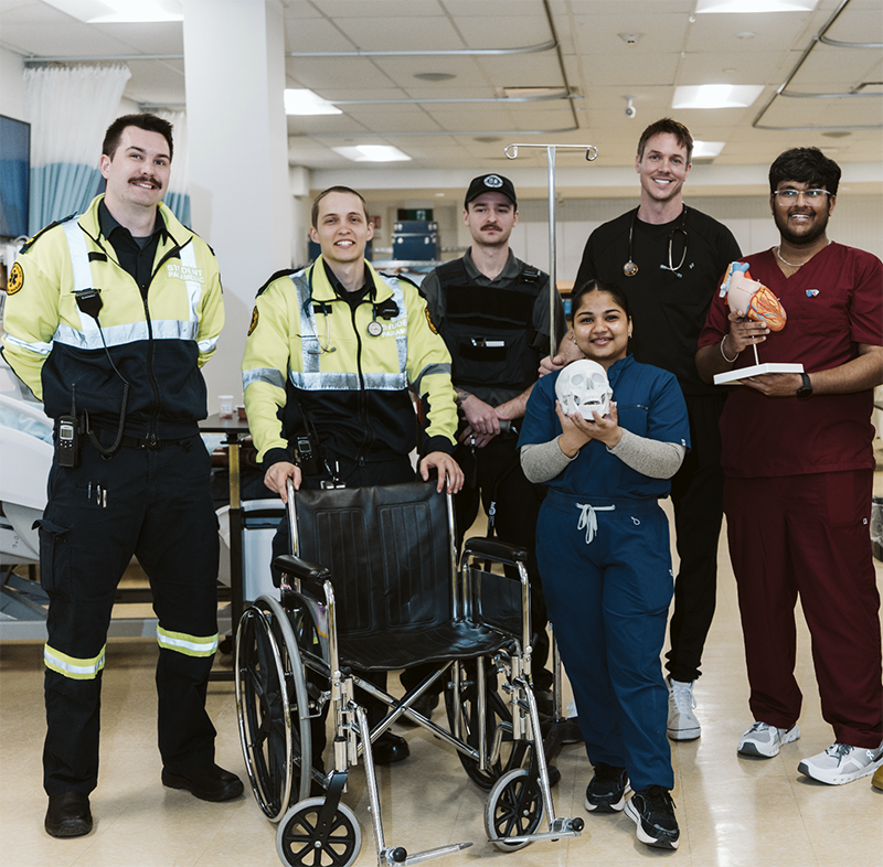 A group of school of health students in paramedic and nursing uniforms.