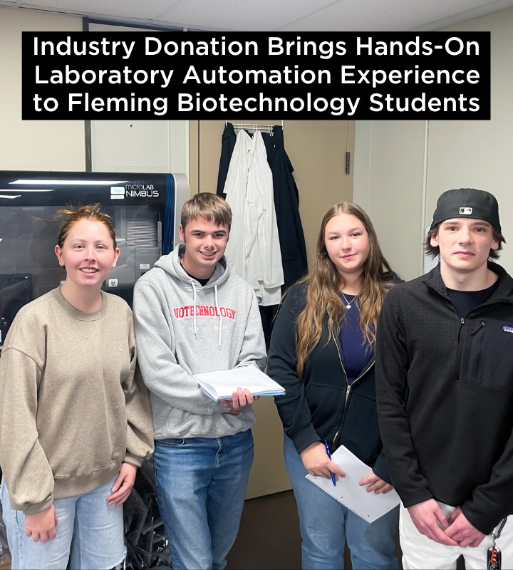 A group of biotechnology students infront of automation equipment